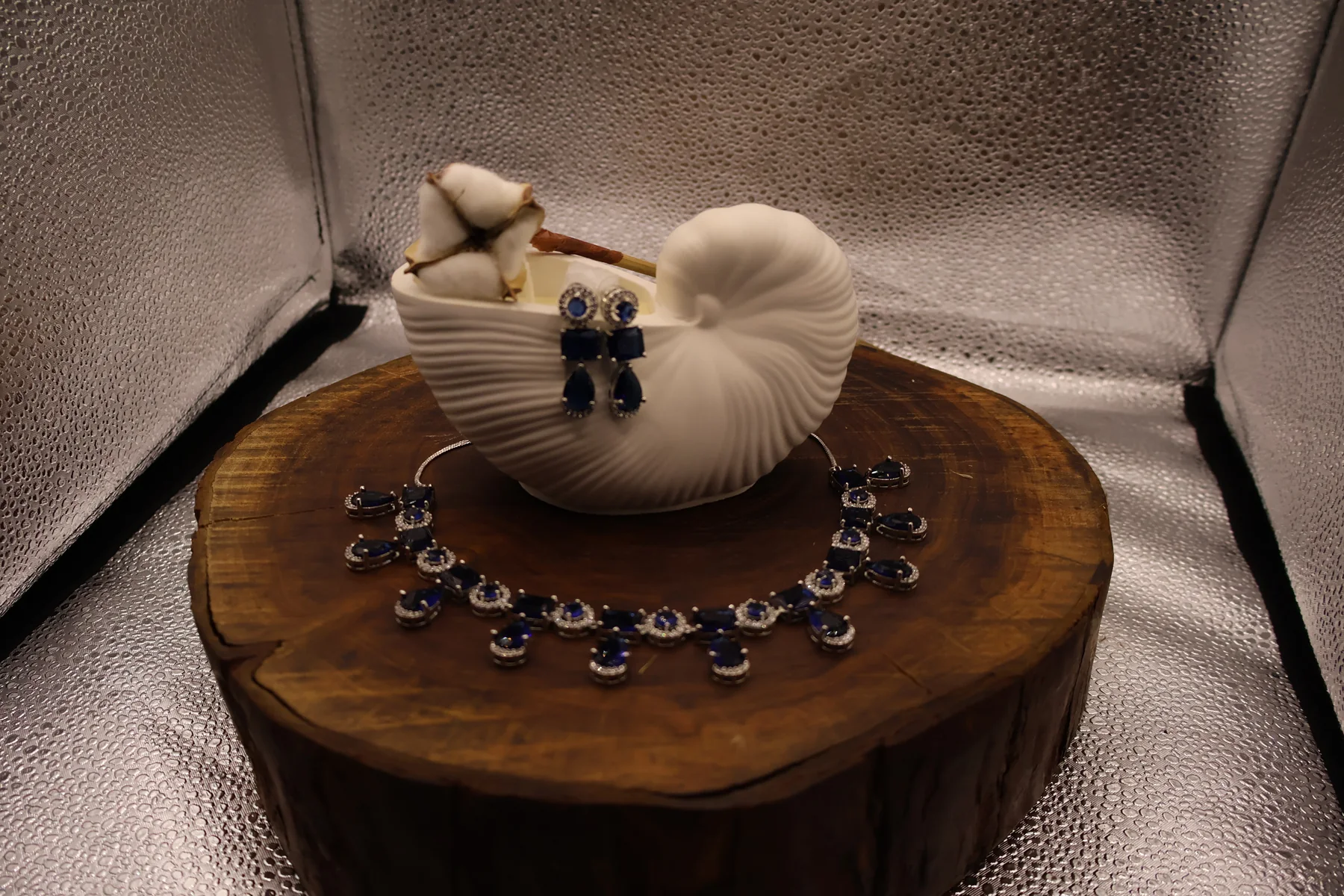 Royal blue crystal necklace and matching earrings displayed with decor